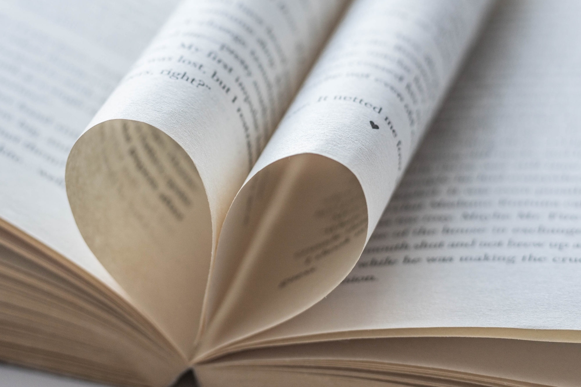 Aufgeschlagenes Buch bei dem die Seiten zu einem Herz geformt sind