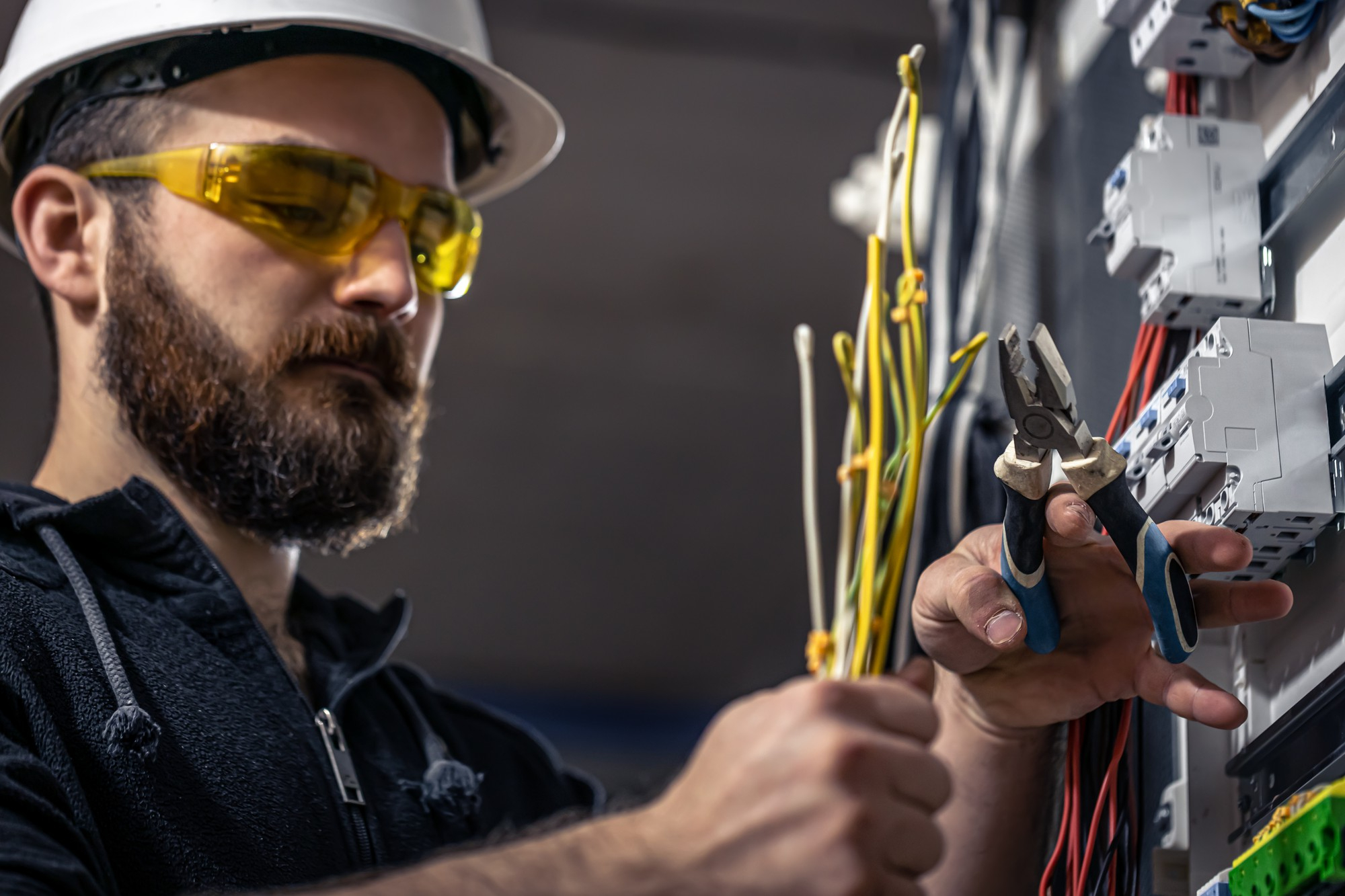 Elektriker bei der Installation eines Schaltschrankes in einem Industriegebäude