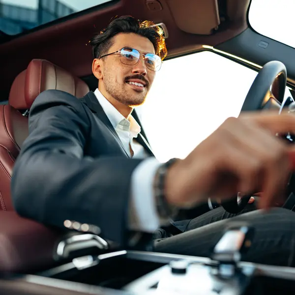 Mann im Luxusauto bedient das Cockpit