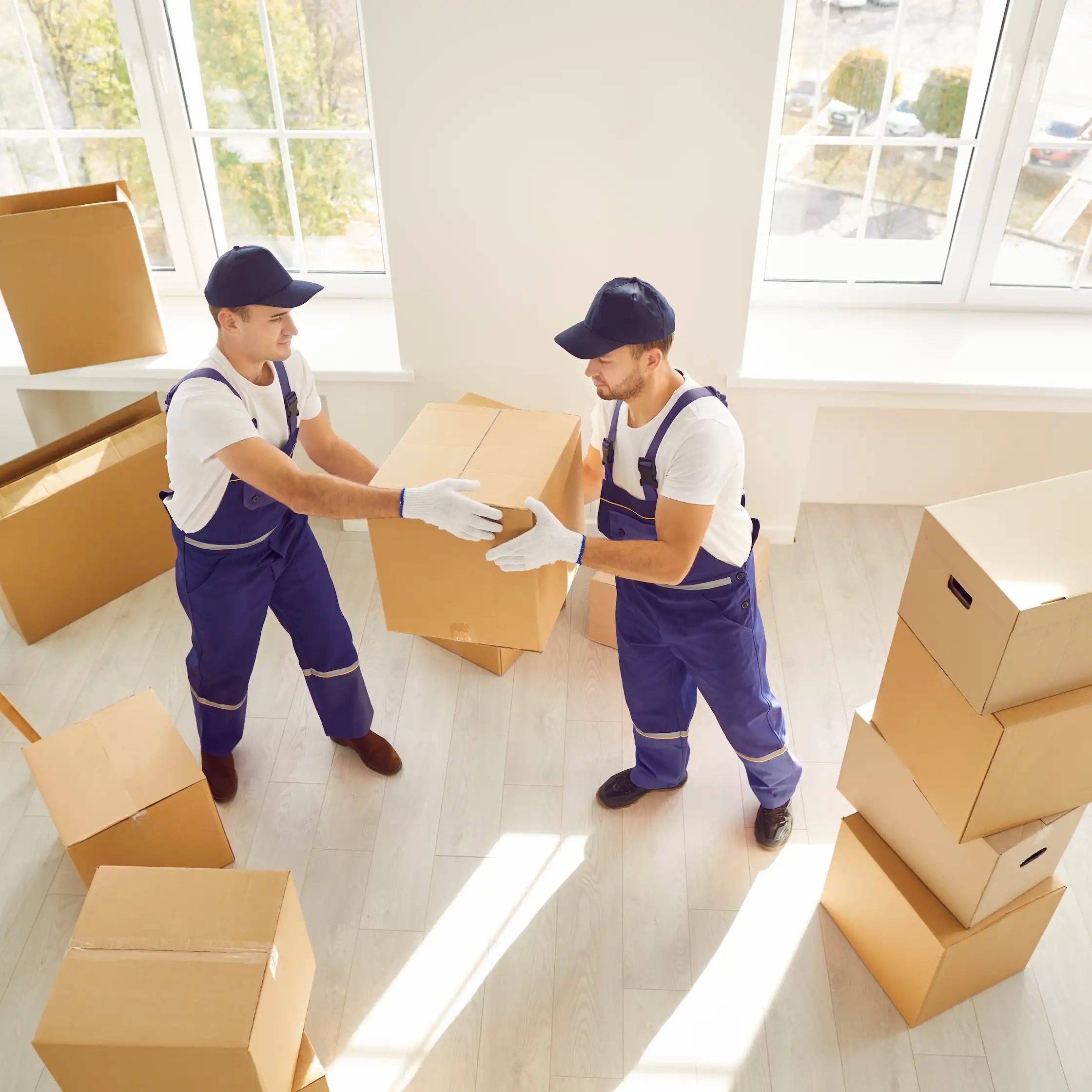 Umzugshelfer tragen Kartons aus Wohnung