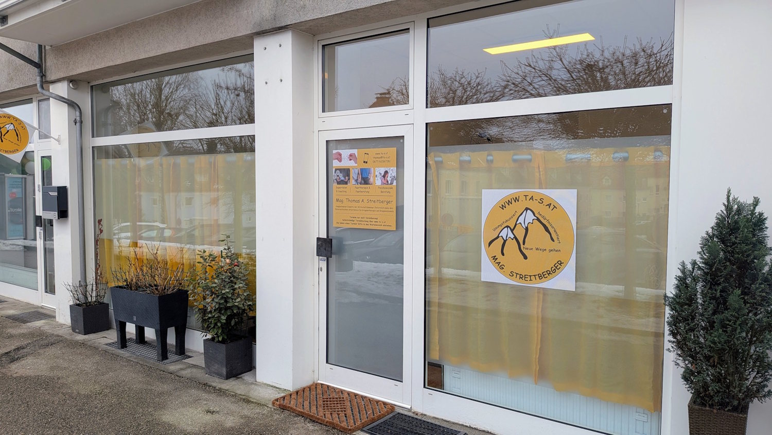 Innenansicht der Praxis mit Sofa, Ohrenstuhl, Pflanzen etc