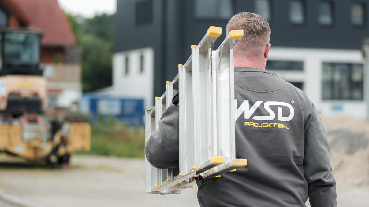 Mitarbeiter der WSD Projektbau trägt eine Leiter zur Baustelle.
