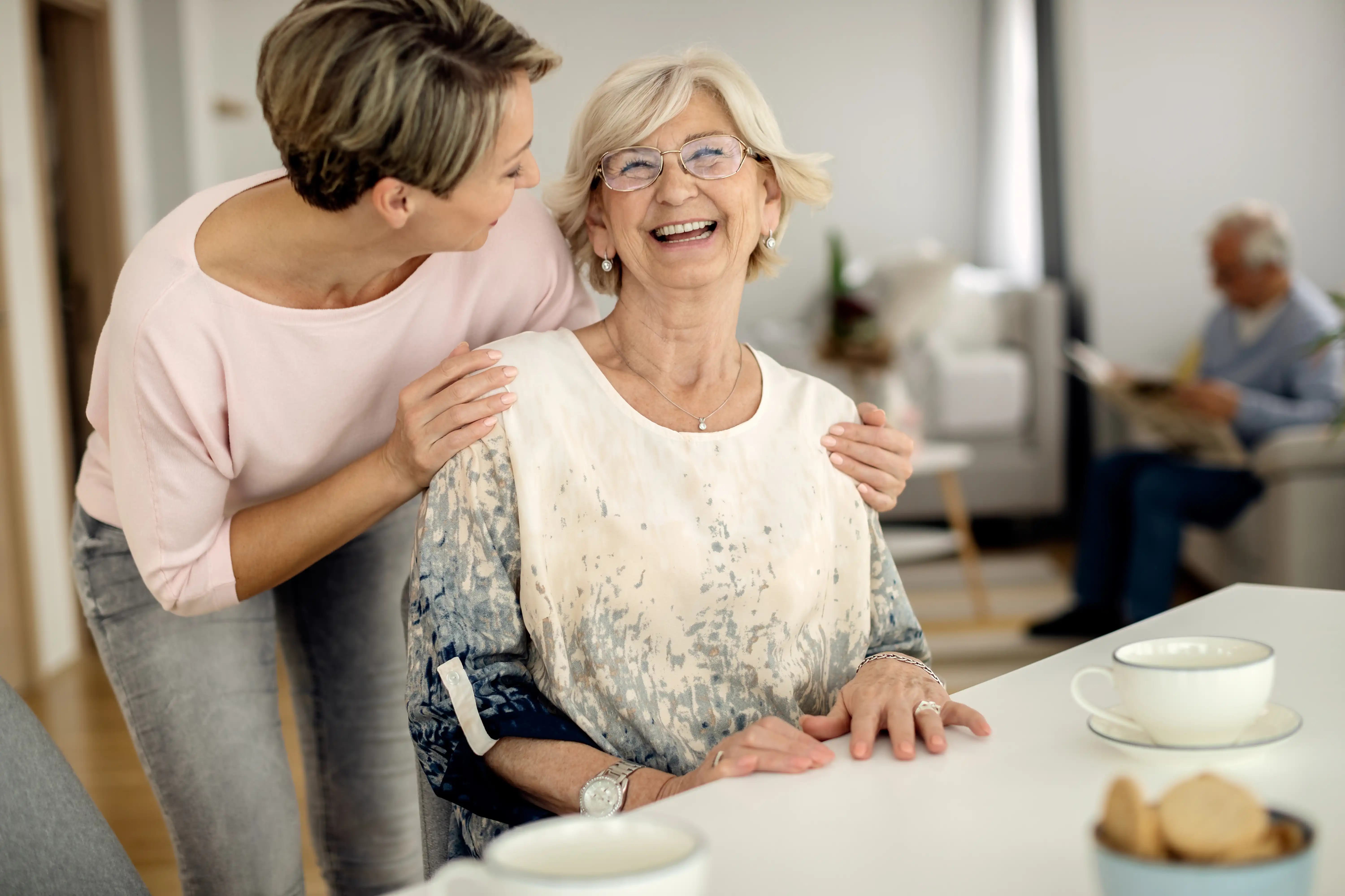 Pflegerin hilft Seniorin beim Aufrichten