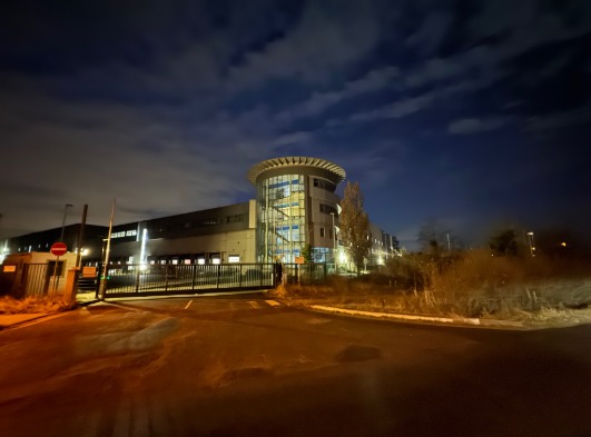 Logistikzentrum in Brieselang bei Nacht mit beleuchtetem Eingangsbereich