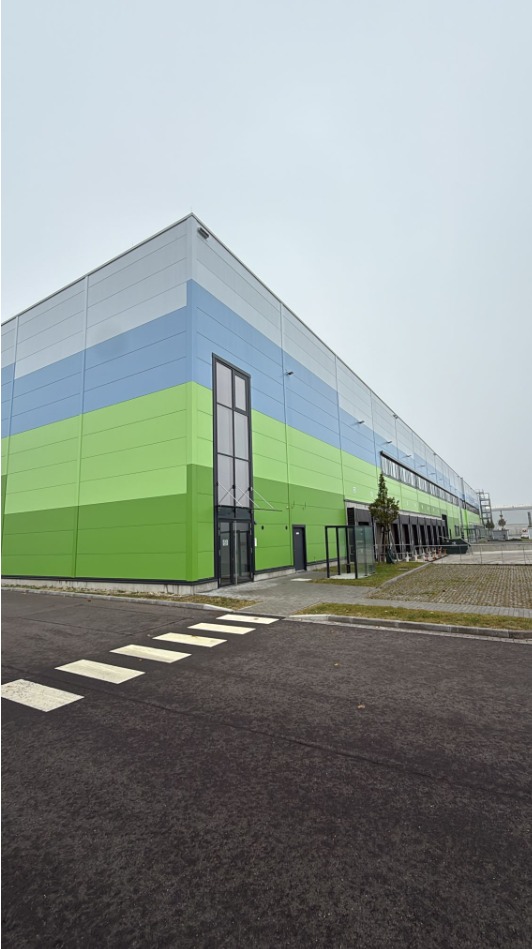 Neu errichtete Logistikhalle in Falkensee mit grün-blauer Fassade