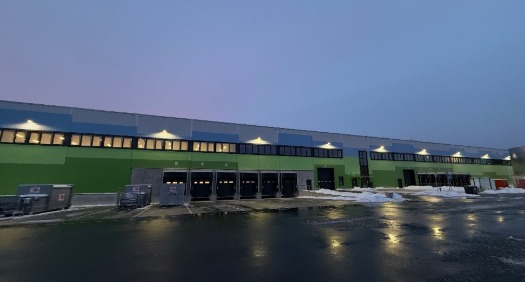 Distributionszentrum in Ludwigsfelde mit beleuchteter Rampenanlage am Abend