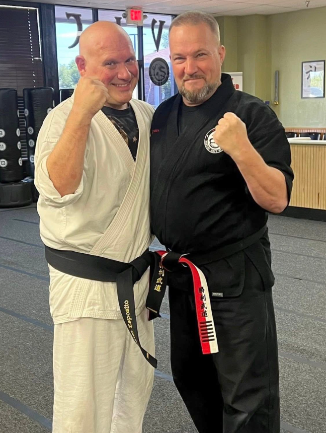 Pete celebrates earning his black belt with Kyoshi Phil.