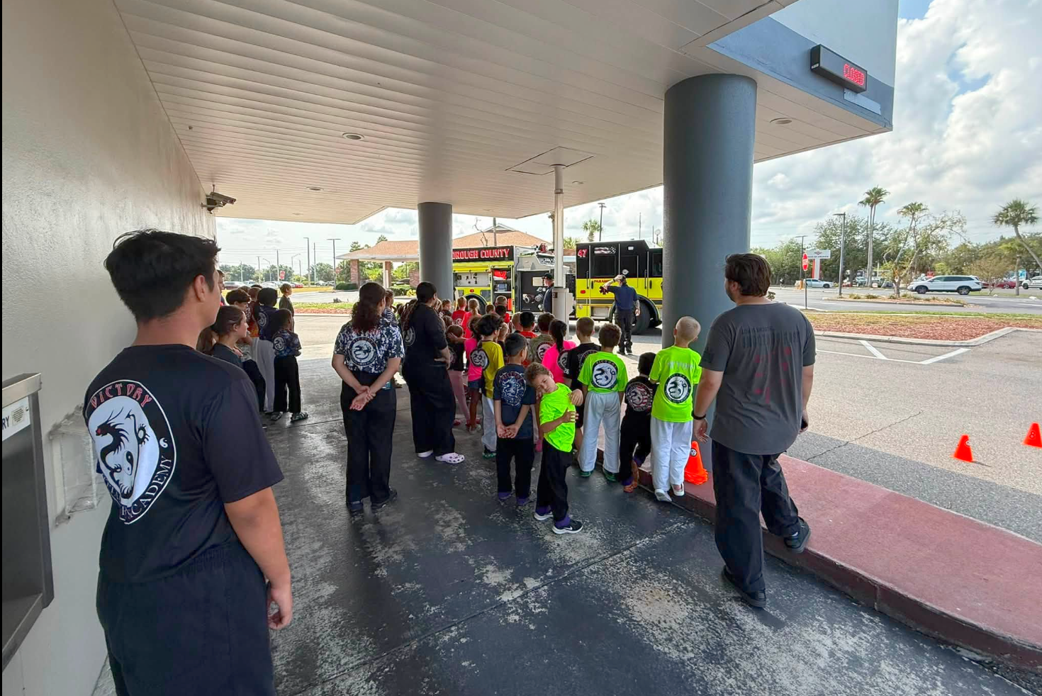Victory students listen to firefighters during a community visit.