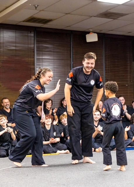 A high five with Sensei Brad celebrates a student’s effort.