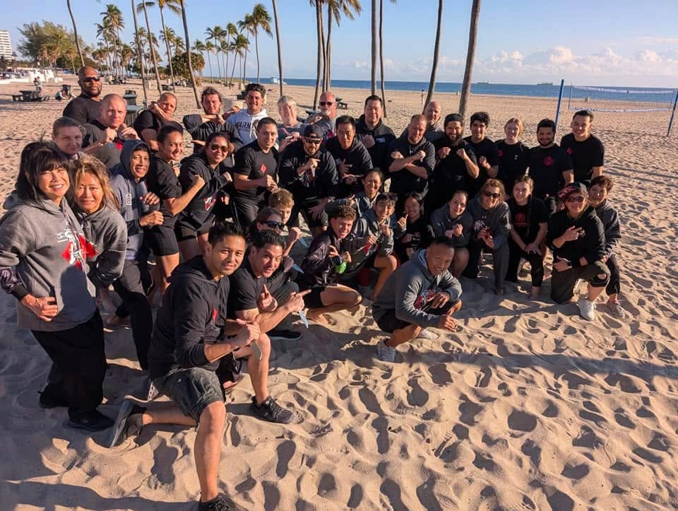 Martial artists gather for training together at the beach.