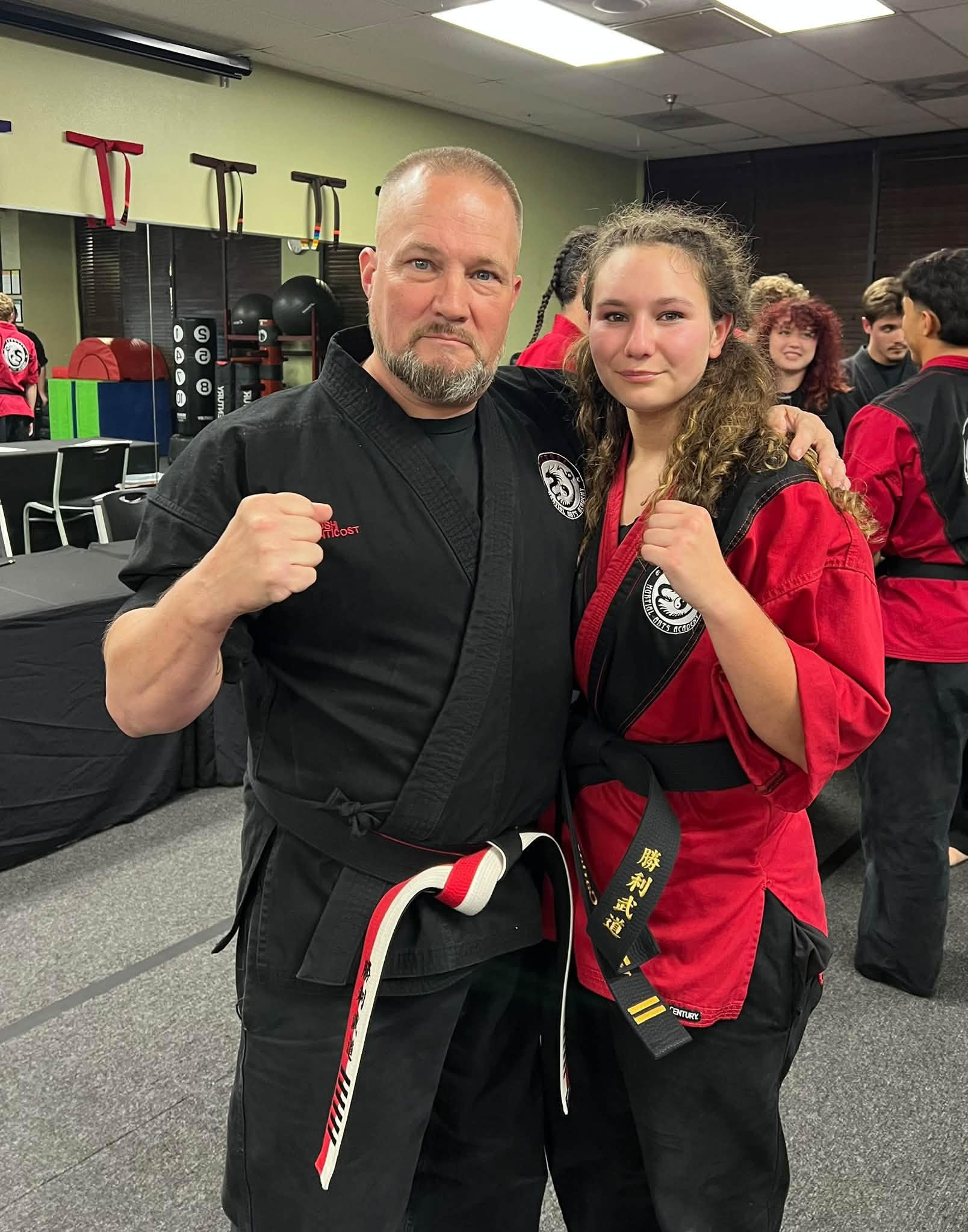 A student celebrates a second degree black belt achievement with Kyoshi Phil.