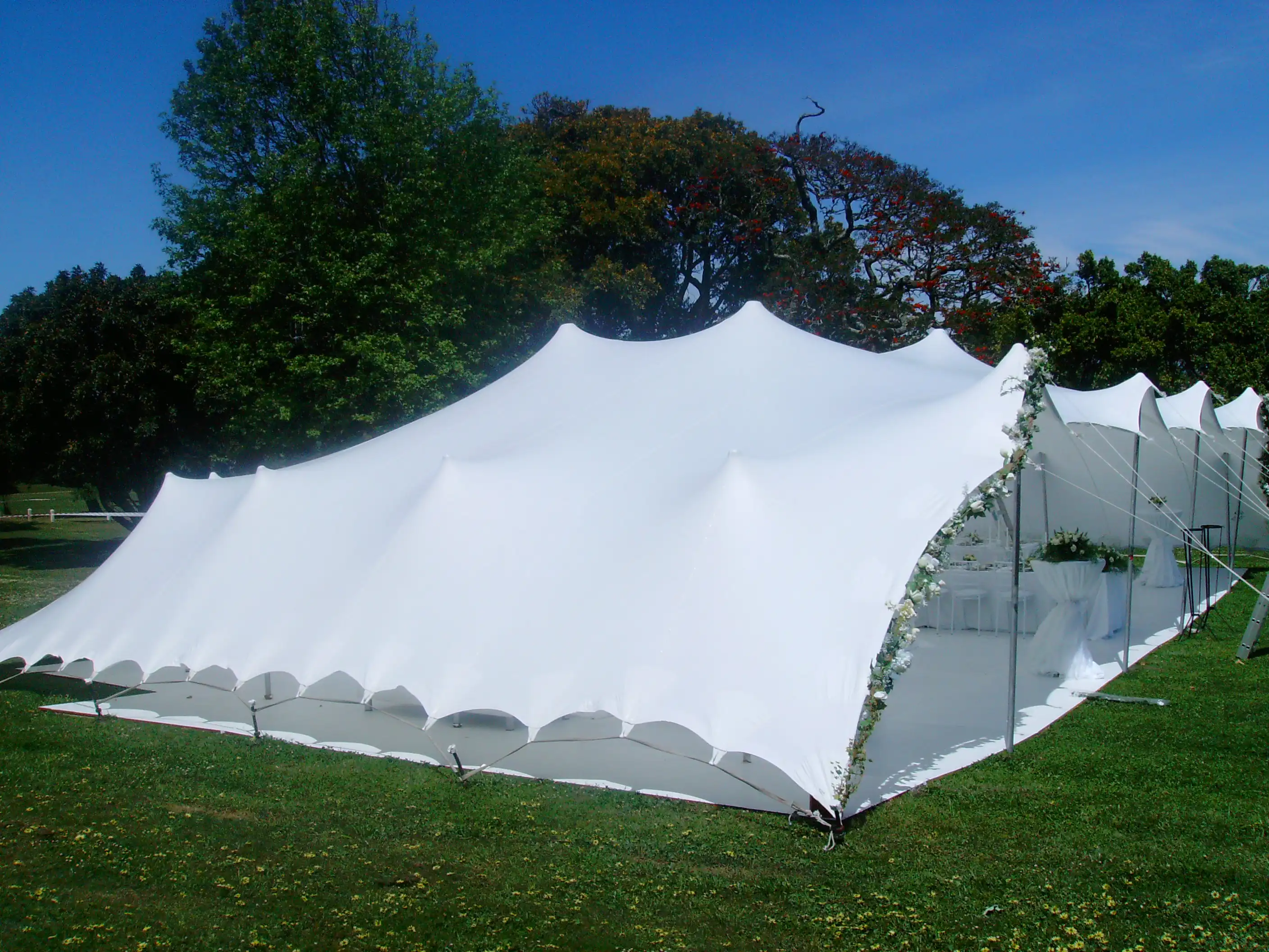 Großes Veranstaltungszelt mit weißem Stoffdach, ideal für Feiern und Events im Freien.