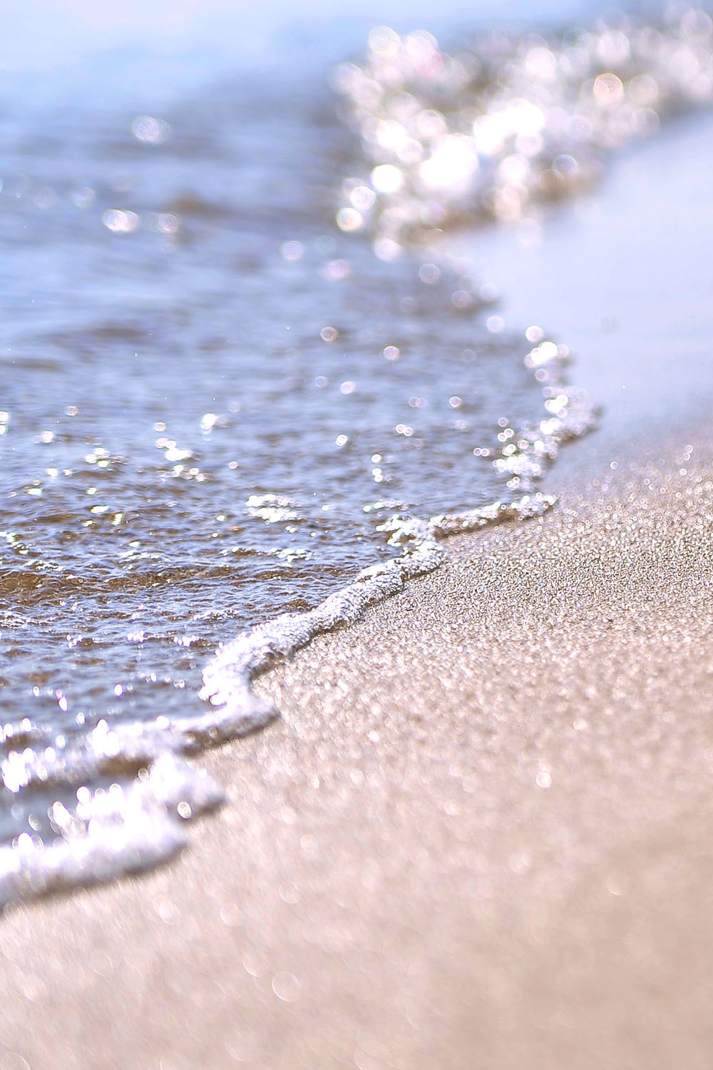 Wellen überspülen sandigen Strand