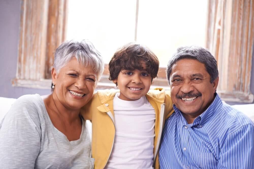 Indian grandparents smiling with their grandn