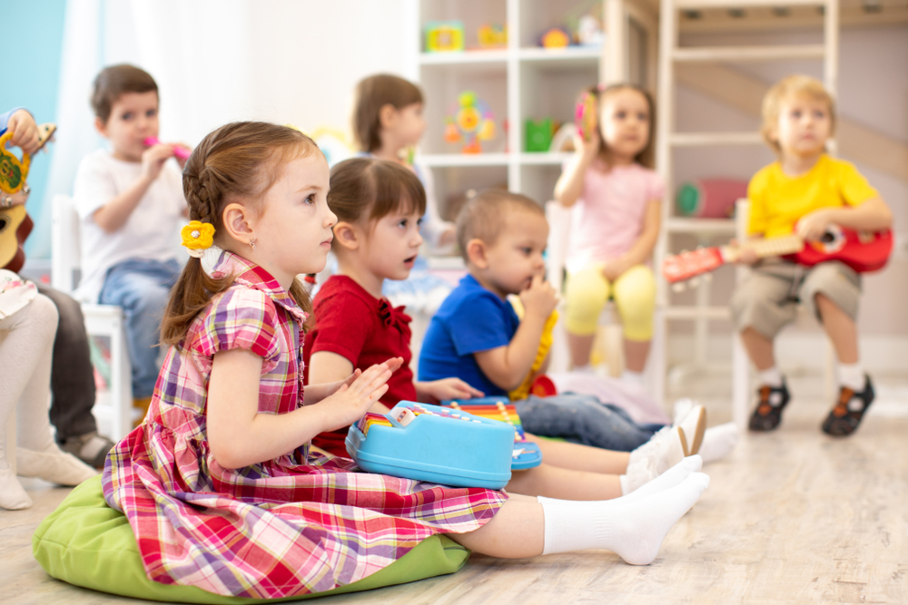 Little girl playing a toy piano in a music class