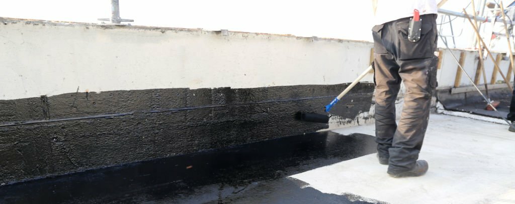 Handwerker trägt Abdichtungsmaterial auf – All-Around-Handwerker Berlin