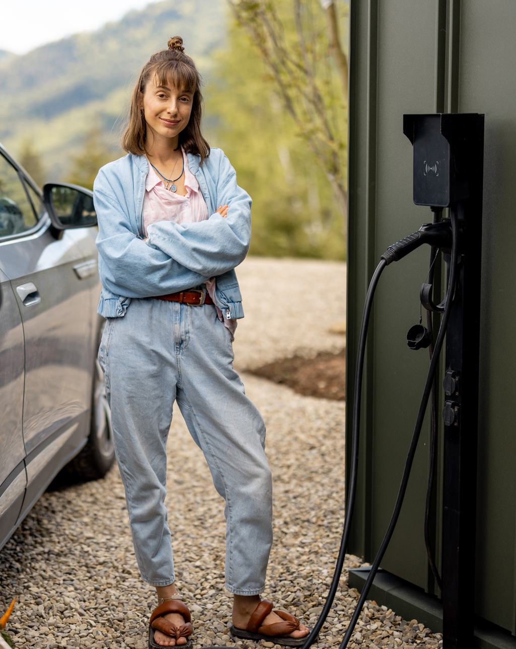 Eine Frau steht neben einem E-Auto beim Laden an einer Wall-Box - einfach, sauber, umweltbewusst - eMobil Stadtwerke Stendal GmbH für private und gewerbliche  Kunden in der Region Altmark, Sachsen-Anhalt