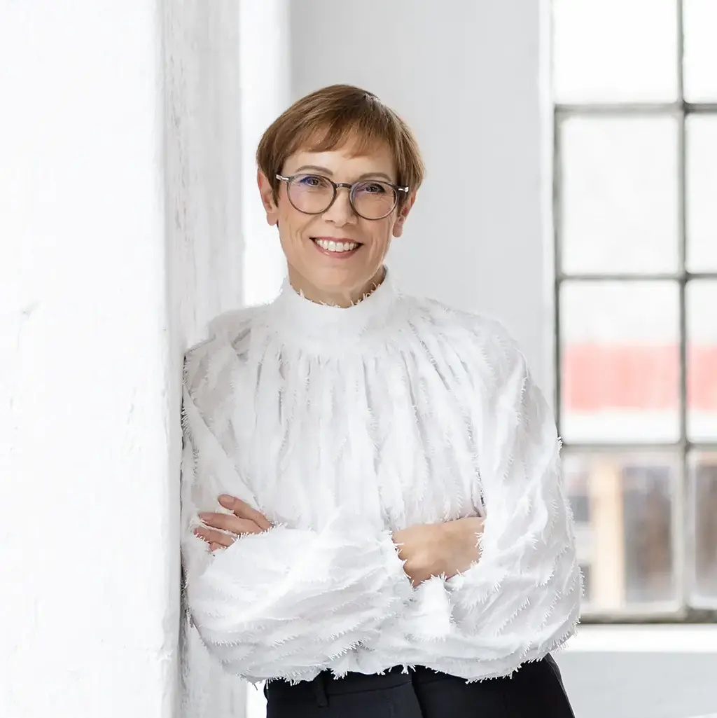 Portraitfoto Monika Dimitrakopoulos-Gratz lehnt an Wand