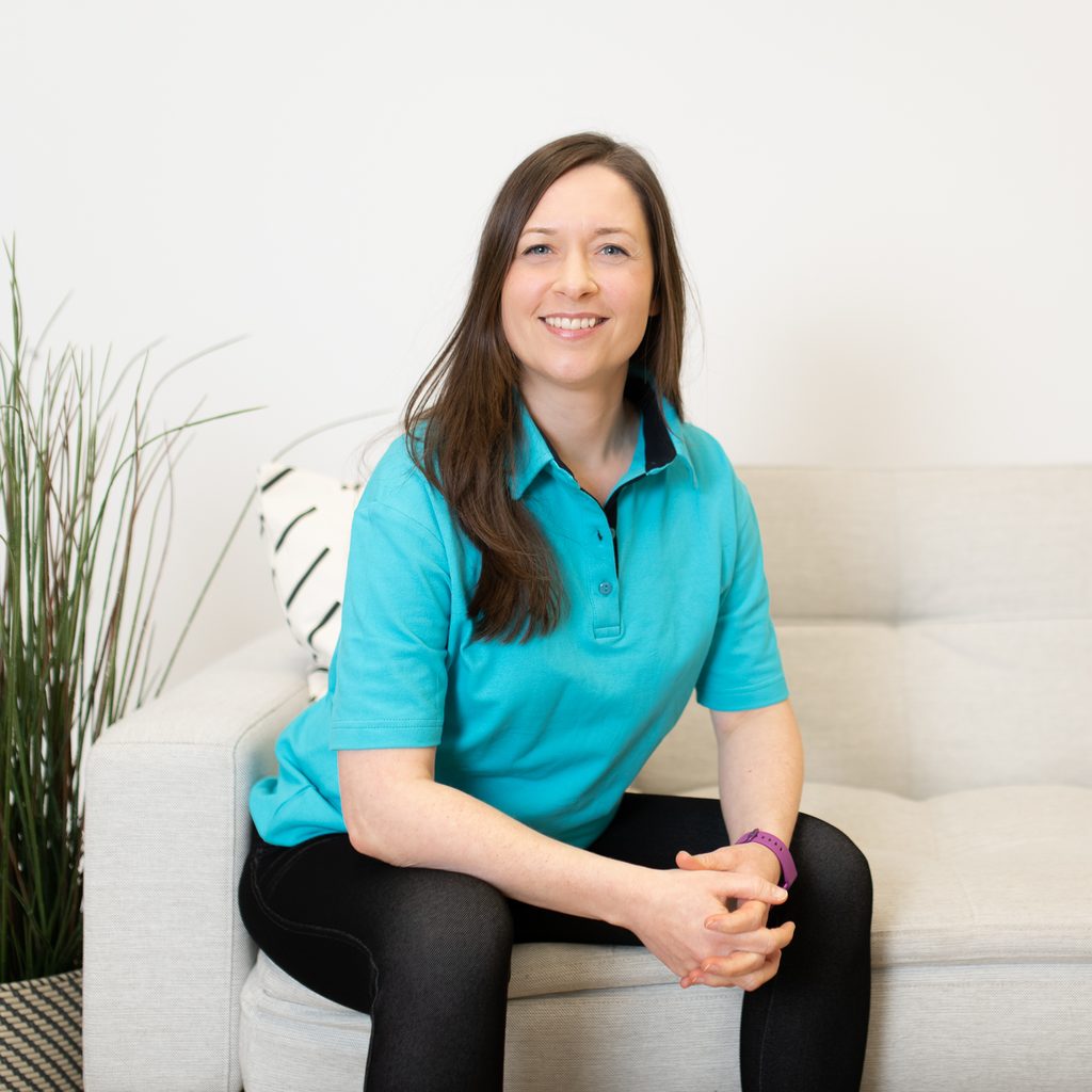 Melanie Seel Physiotherpie Bahrenfeld am Bahrenpark aufrecht auf einem Sofa sitzend und freundlich lächelnd