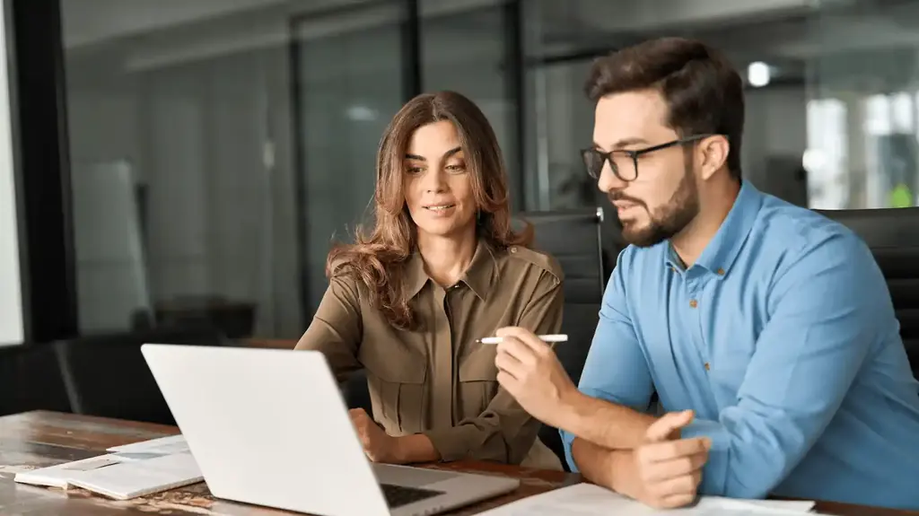Mitarbeiter arbeitet Versicherungsverträge am Laptop durch
