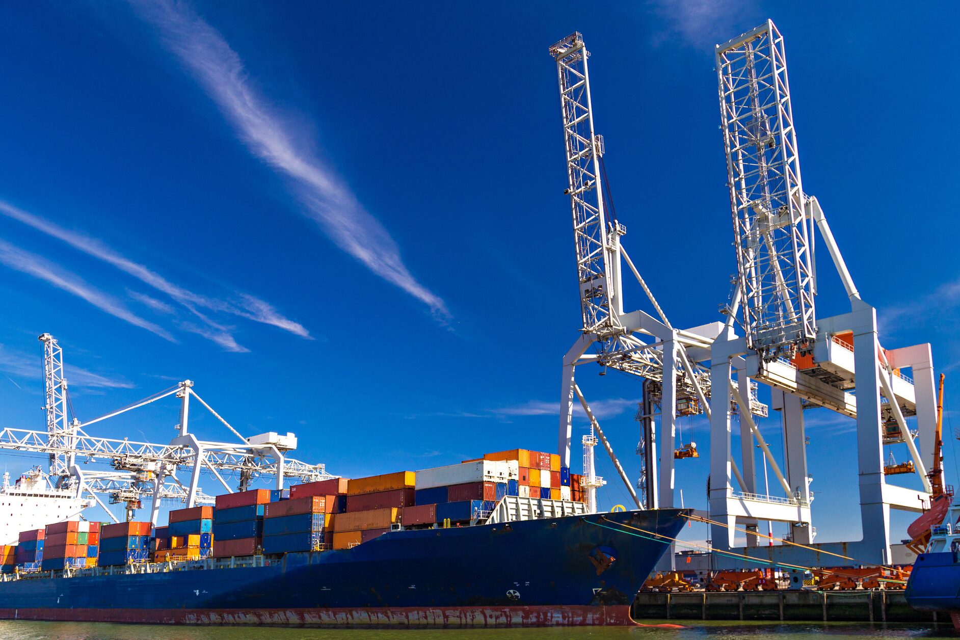 Ein Containerschiff mit Kranen im Hintergrund