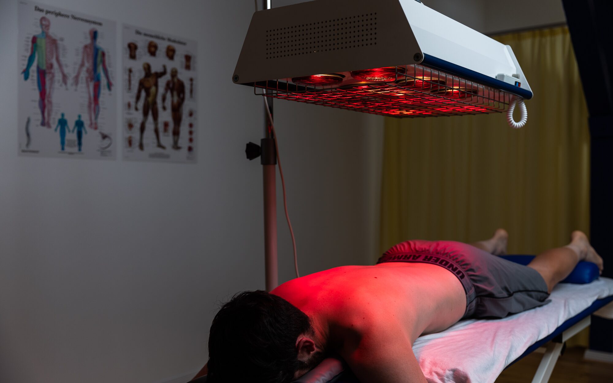 Rotlichttherapie am Rücken eines Patienten mit medizinischem Infrarotgerät