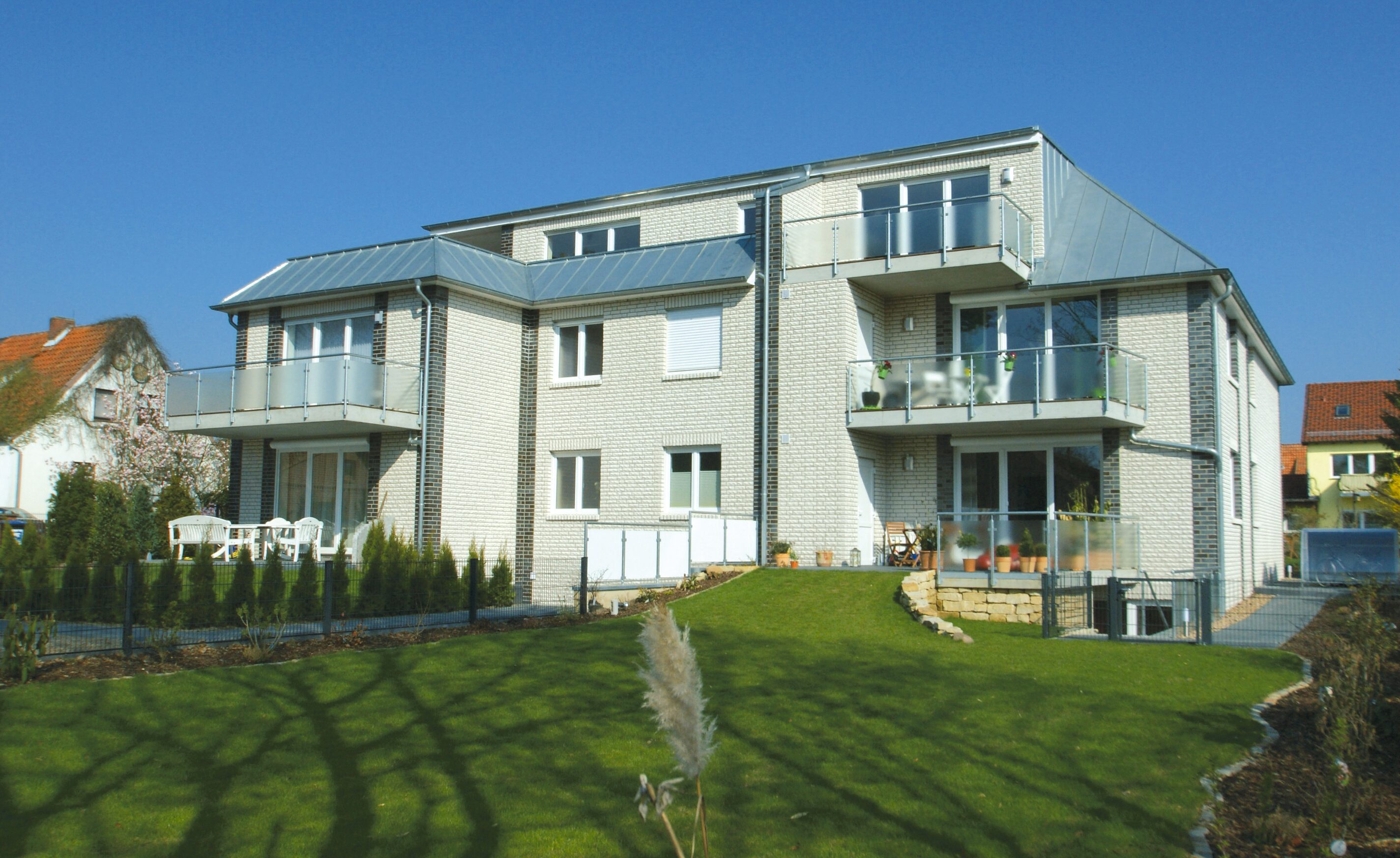 Dreigeschossiges Wohnhaus mit hellem Klinker und Garten