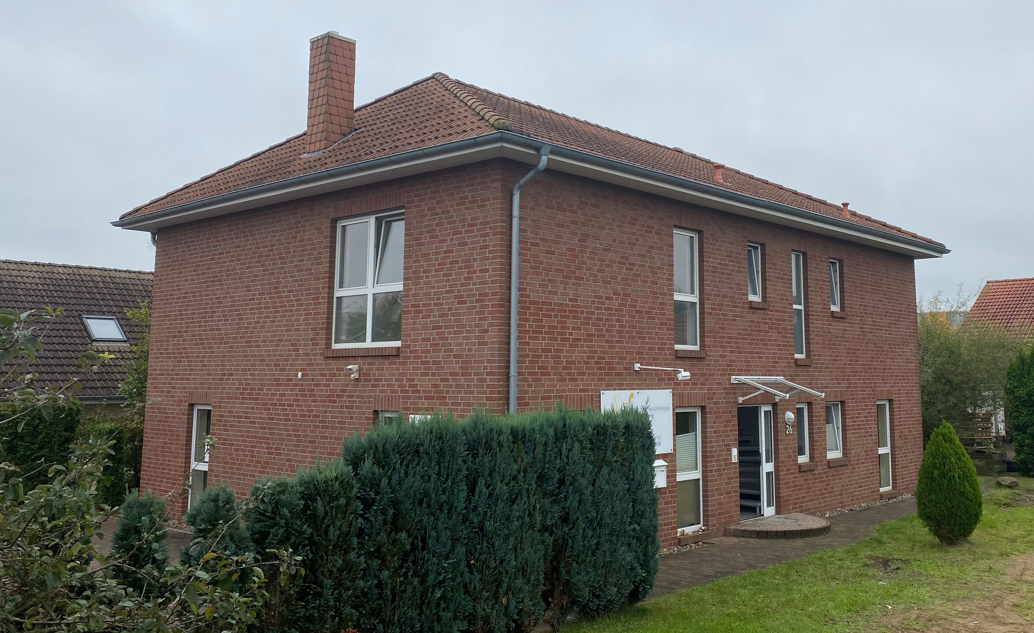 Zweigeschossiges Backsteinhaus mit Walmdach und Schornstein