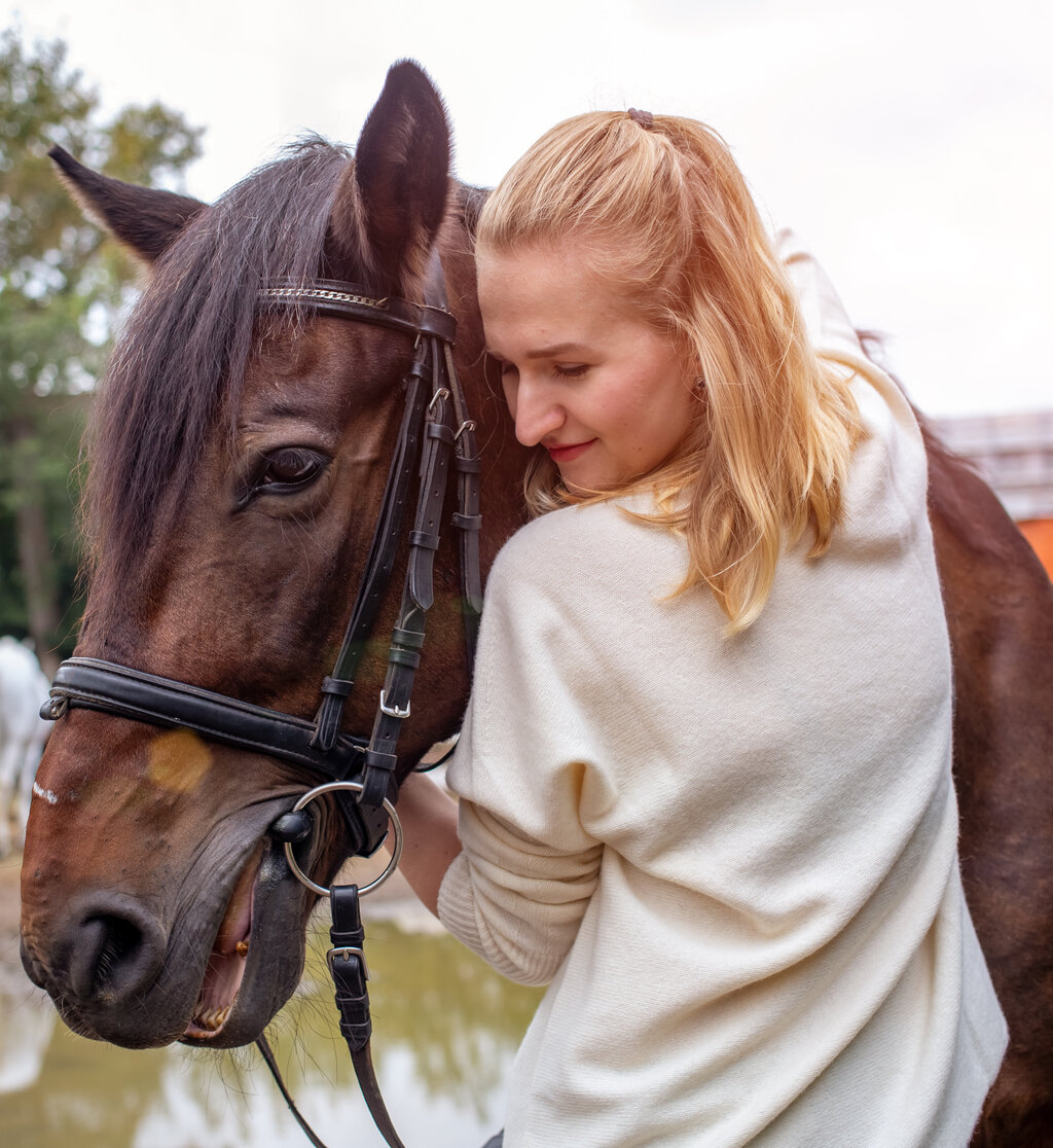 A woman hugging a brown horse