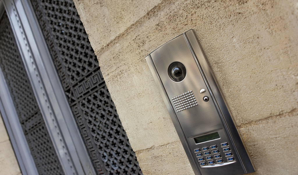 Nahaufnahme einer modernen Gegensprechanlage an einer Steinfassade eines französischen Hauses
