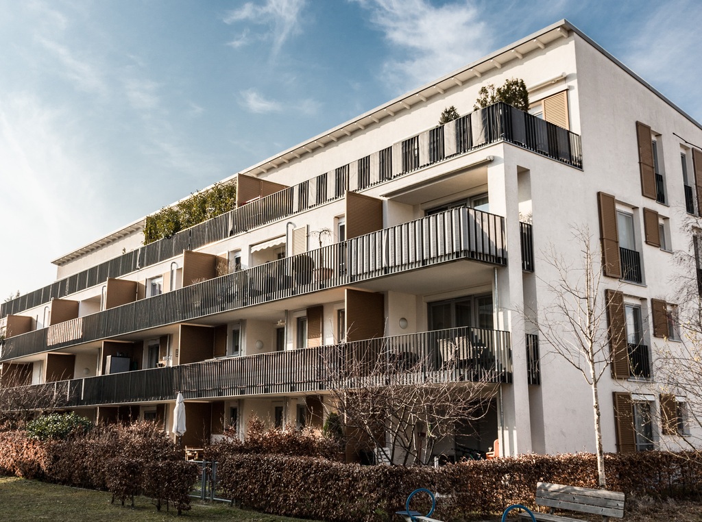 Modernes Mehrfamilienhaus mit Balkonen und Vorgarten