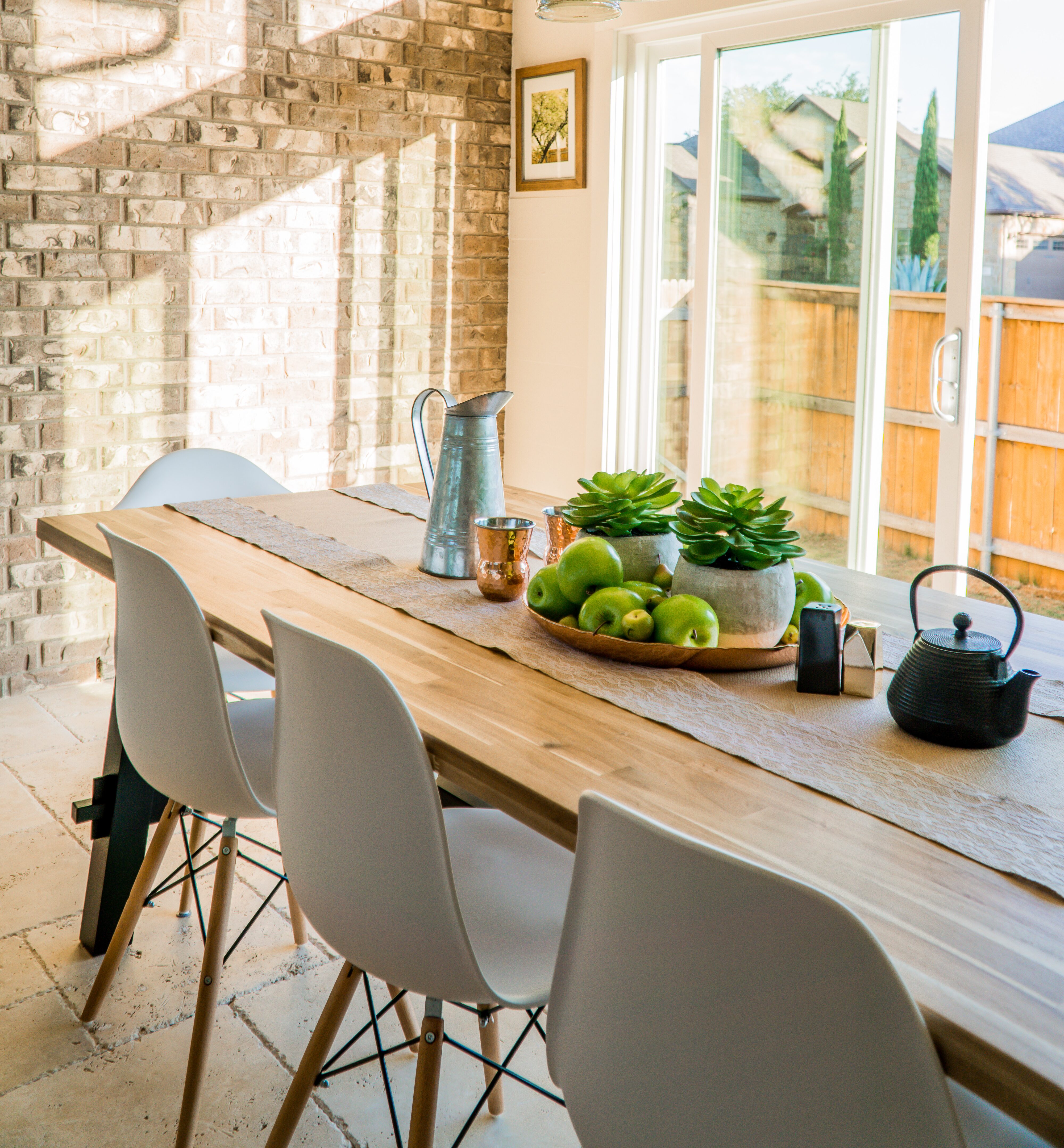 Modern wooden dining room, set with fruit on table, warm lighting