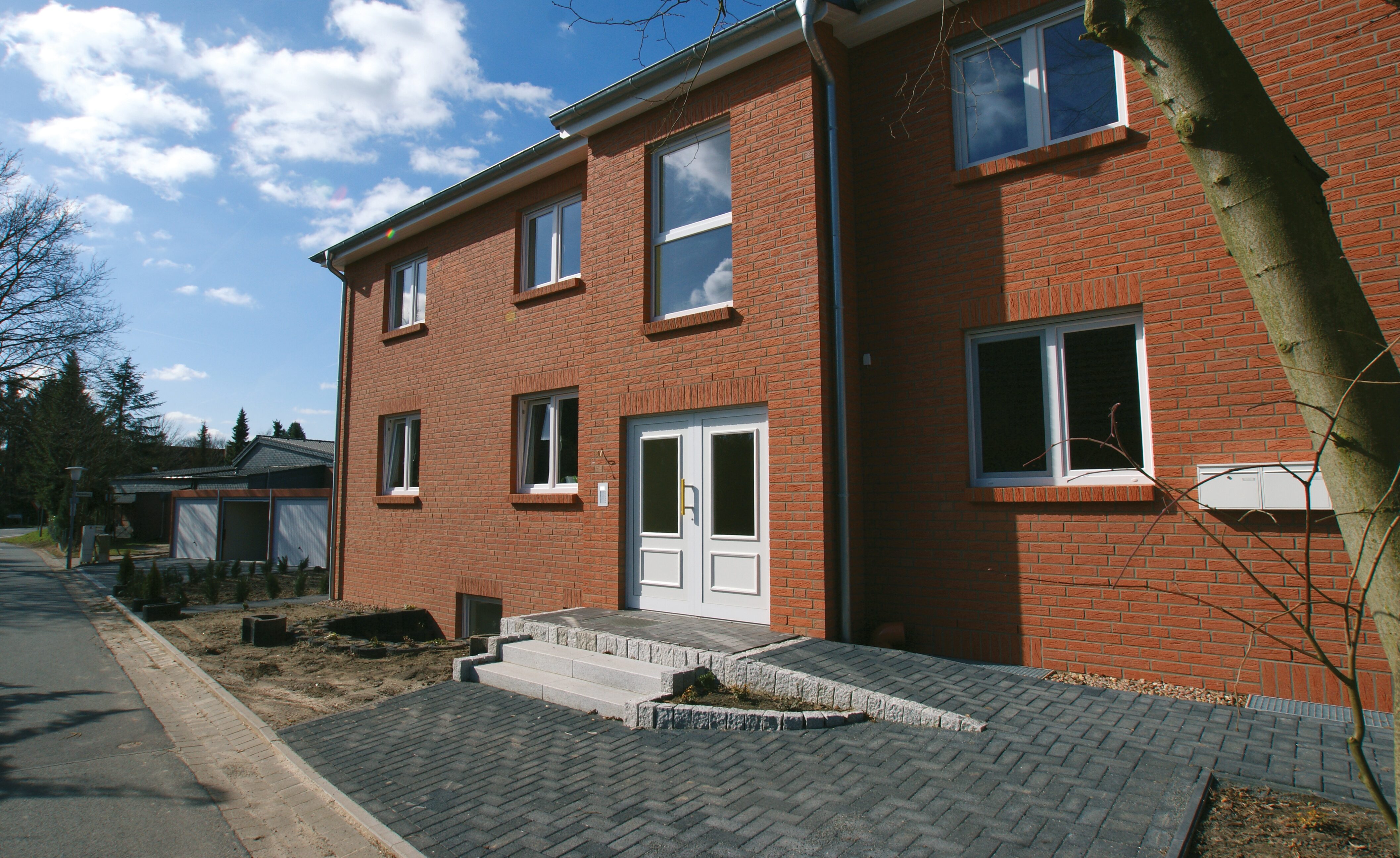 Backsteinwohnhaus mit Eingangsbereich und Pflasterweg