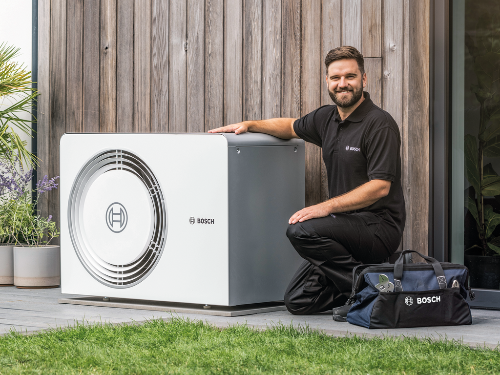 Zwei Hände halten einen Tablet-Computer, aus dem verschiedene Handwerkszeuge herausragen, dahinter ein Meesenburg-Logo