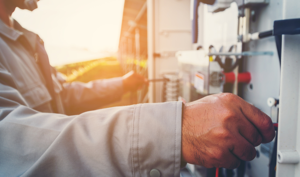 Solarkraftwerk zur Innovation grüner Energie; Ingenieur oder Elektriker, der an Kontroll- und Wartungseinrichtungen im Solarkraftwerk arbeitet