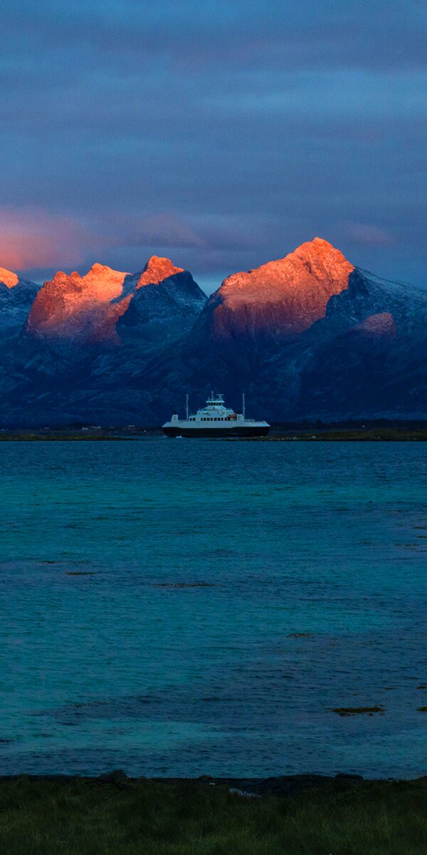 Ferge med rød solnedgang på fjellene de syv søstre i bakgrunnen