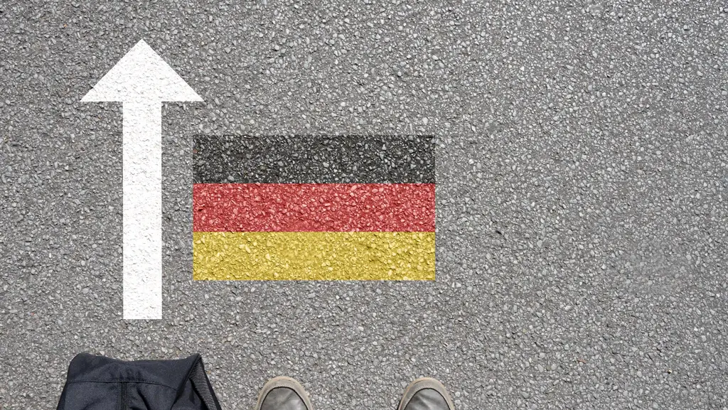 Deutschlandfahne auf Boden mit Pfeil - auswandern