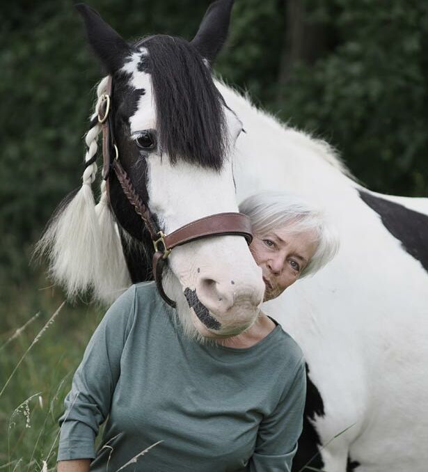 Anne Janzen - Tierkommunikatorin und Gestalttherapeutin steht von einem Sofa auf