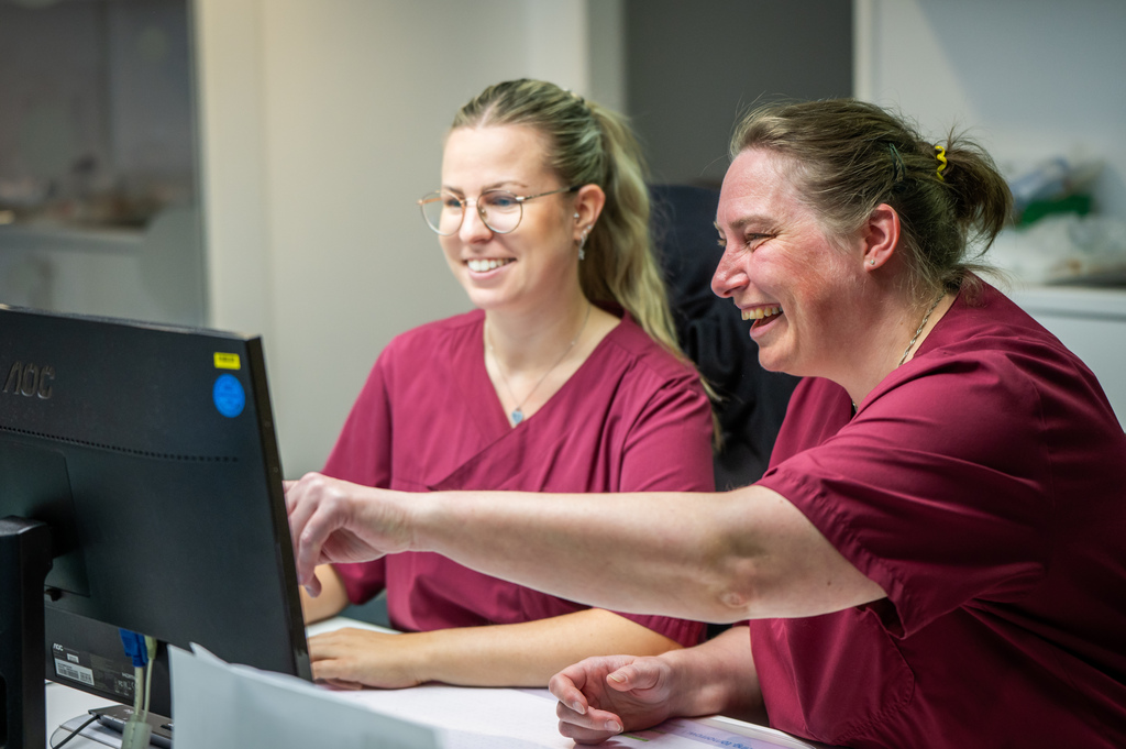 Zwei Mitarbeiterinnen am PC mit Lächeln