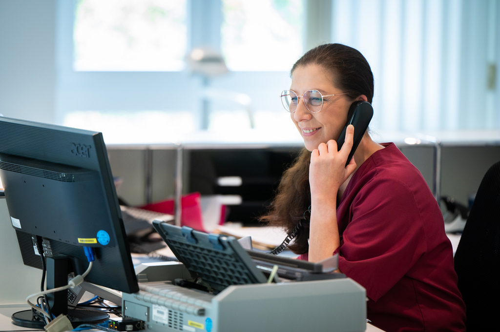 Mitarbeiterin telefoniert am Empfang