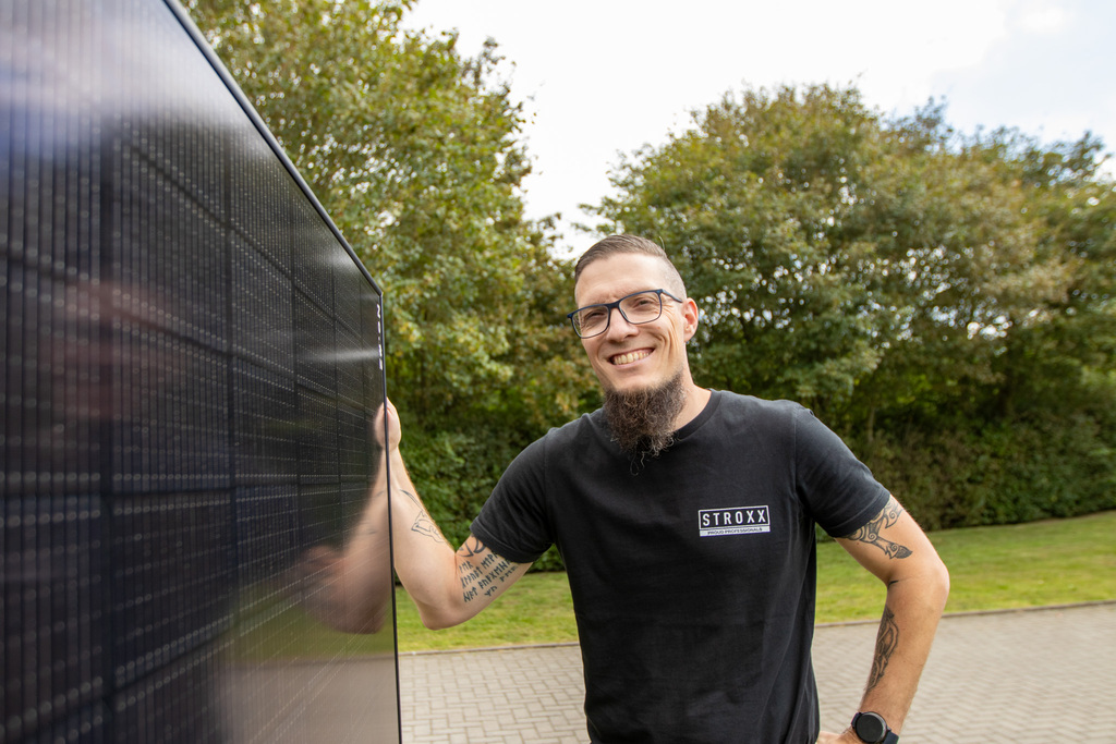 Zwei Hände halten einen Tablet-Computer, aus dem verschiedene Handwerkszeuge herausragen, dahinter ein Meesenburg-Logo
