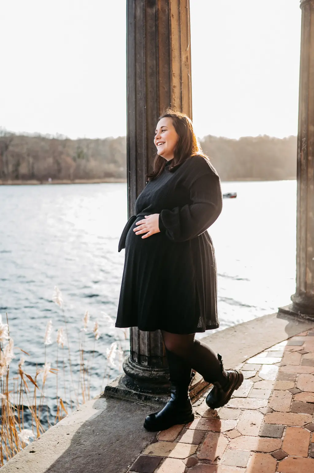 Eine schwangere Frau an einem schönen See während einem Babybauch-Shooting in Berlin. 