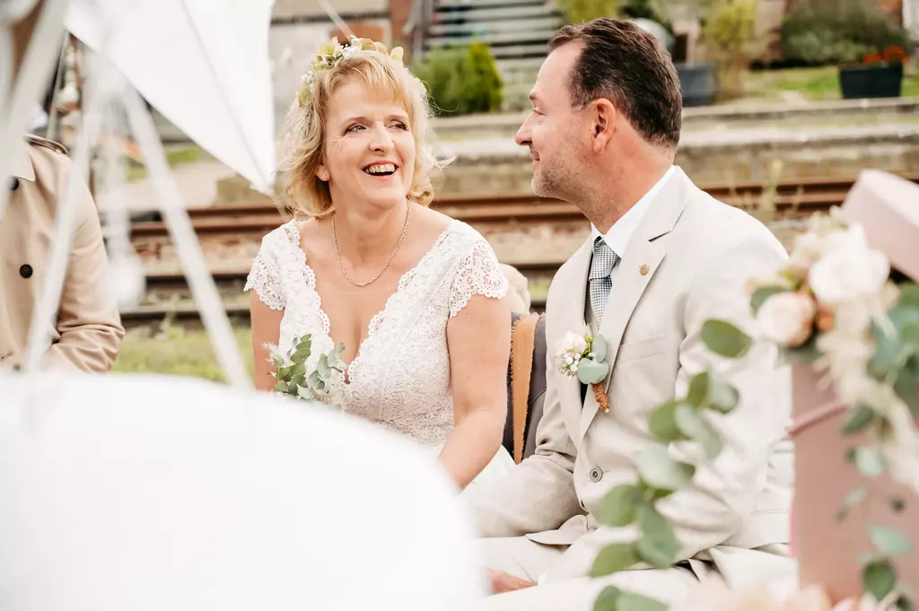 Ein Hchzeitsfotograf in Berlin fängt ein glückliches Brautpaar während der Feier ein