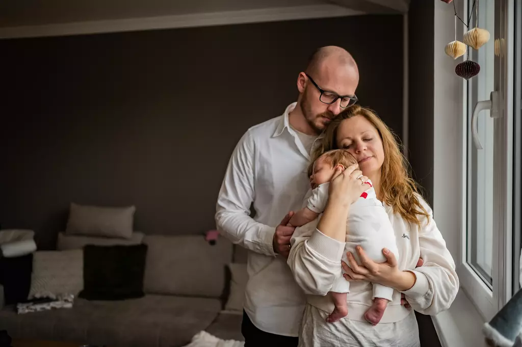 Ein Pärchen mit ihrem Baby bei einem Newborn Shooting in Brandenburg
