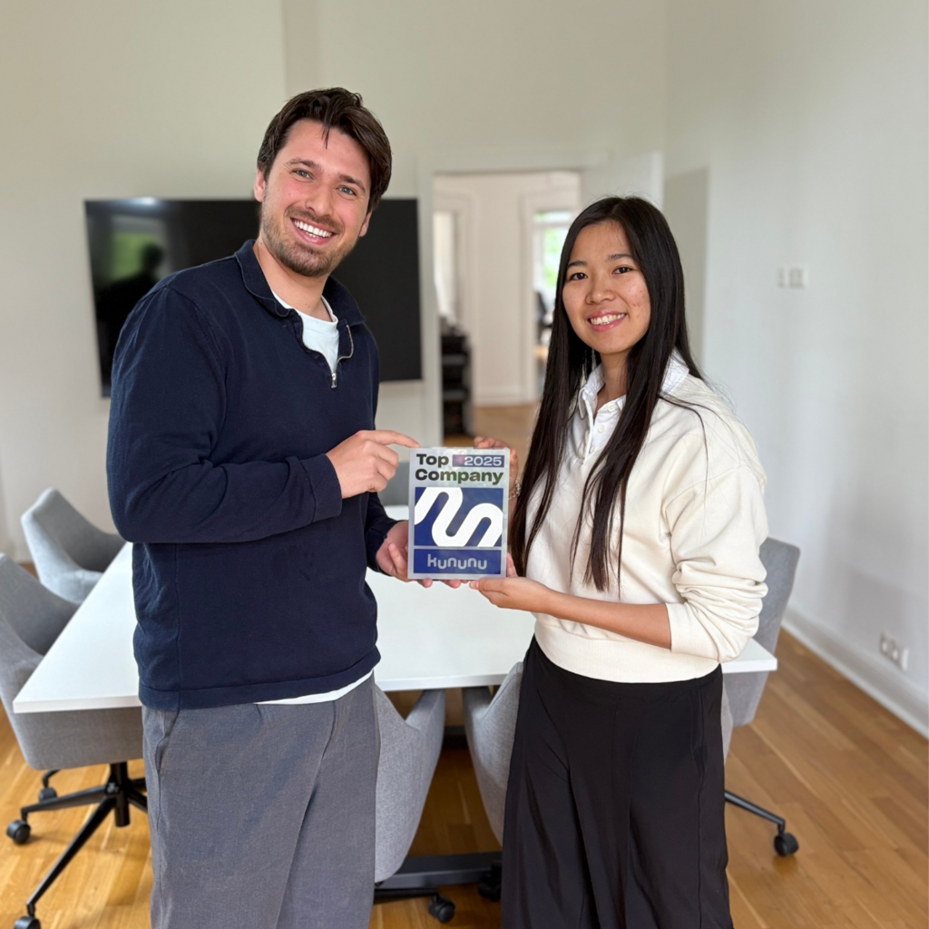 Bünyamin Özkan Links und Linh Ngoc halten das Top-Arbeitgebersiegel 2025 hoch