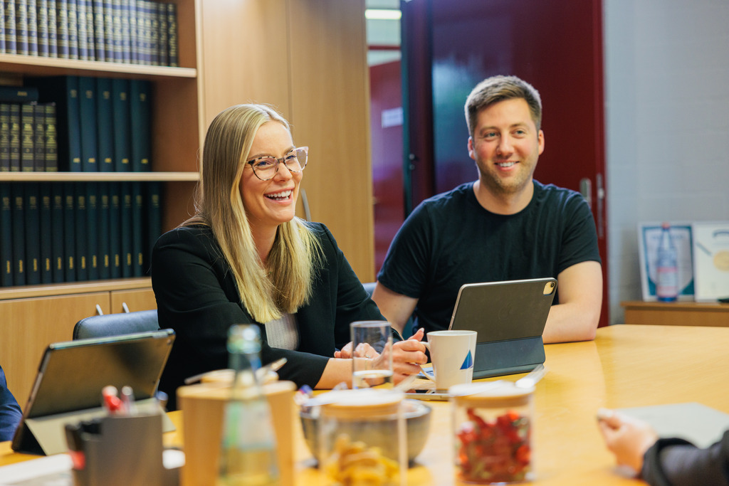 Mann und Frau lachend in einem Meeting