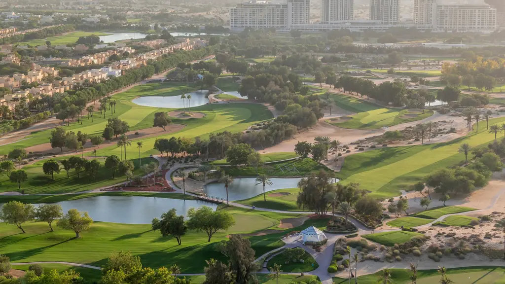 Drohnenaufnahme Golfplatz mit Teichen und Straßen und Palmen in den Vereinigten Arabischen Emirate