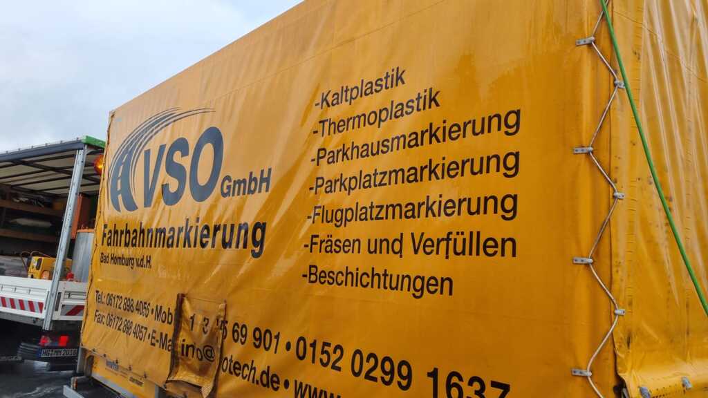 Gelber LKW-Planenaufbau mit Firmenlogo und Beschriftung der VSO GmbH Fahrbahnmarkierung, inklusive Leistungen wie Kaltplastik, Thermoplastik, Parkhausmarkierung, Parkplatzmarkierung, Flugplatzmarkierung, Fräsen und Verfüllen sowie Beschichtungen.