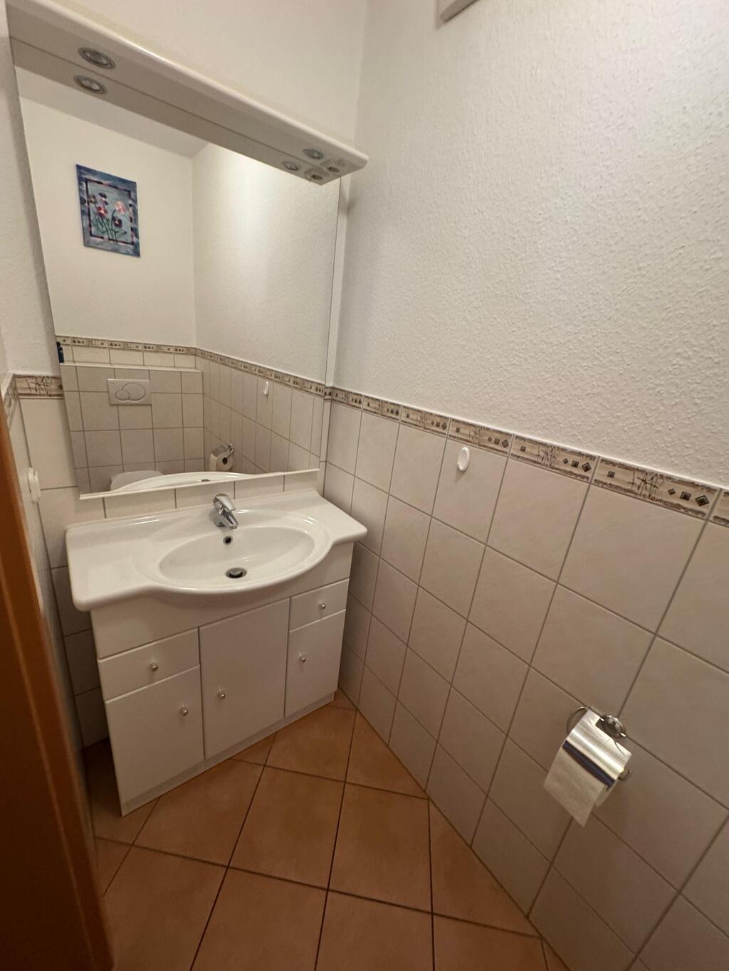 Badezimmer vor der Sanierung mit altem Waschbecken und kleinem Raum