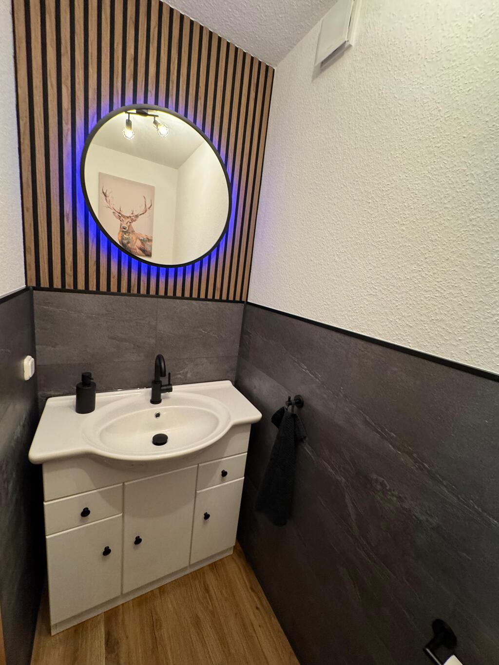 Badezimmer nach der Sanierung mit modernem Waschbecken und hellem Design